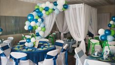 a room filled with tables covered in blue and green balloons