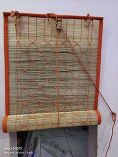 a close up of a bamboo window covering with orange lines on the bottom and sides