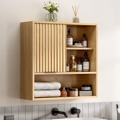 a wooden shelf above a bathtub filled with personal care items