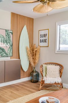 a living room filled with furniture next to a wooden table and wall mounted surfboards