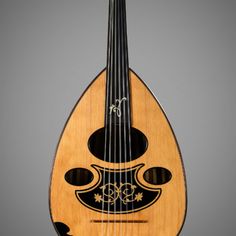 a wooden instrument with black and white designs on the body, neck and back sides