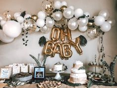 a table topped with lots of balloons and cake