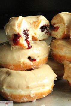 glazed doughnuts are stacked on top of each other with cranberry filling