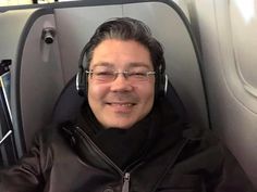 a man wearing headphones sitting in an airplane