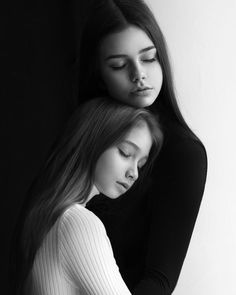 two young women are hugging each other in black and white