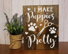 a wooden sign that says i make puppies pretty next to a potted plant