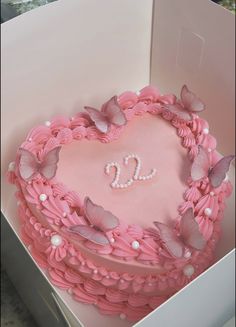 a heart shaped cake in a pink box with butterflies on the top and letter d