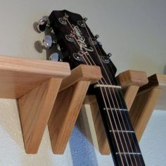 an acoustic guitar is propped up against a wall with a wooden shelf attached to it