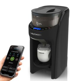 a person holding a cell phone next to a coffee maker and an appliance