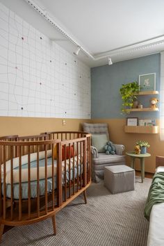 a baby's room with a crib, chair and ottoman