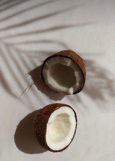 two coconuts cut in half on a white surface