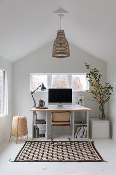 a home office with a desk, computer and bookshelf