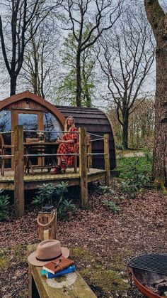 a person sitting on a wooden bench in the woods