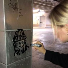 a woman writing graffiti on the side of a building