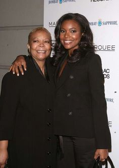 two women standing next to each other on a red carpet