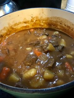 a pot filled with stew sitting on top of a stove