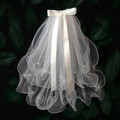 a white veil hanging from the side of a tree