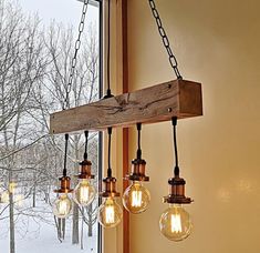 the light bulbs are hanging from the wooden beam in the window sill, which is decorated with chains and glass globes