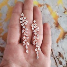 a person holding two pairs of earrings in their hand