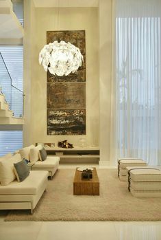 a living room filled with furniture and a chandelier hanging over the top of it