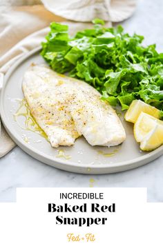 baked red snapper fish on a plate with lettuce and lemon wedges