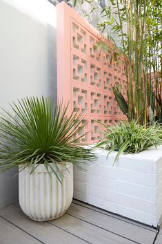 two white planters sitting on top of a wooden floor