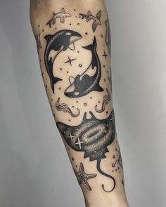 a man's arm with tattoos on it and an image of two dolphins in the ocean