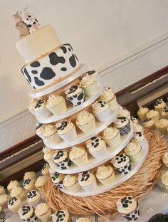 a large cake with cupcakes on it in the shape of a cow print