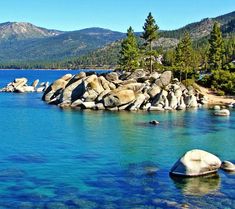 the water is crystal blue and there are many rocks in the middle of the lake