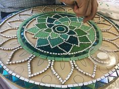 a person making a mosaic design on a table