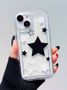 a woman holding up a clear case with black stars on the front and back of it