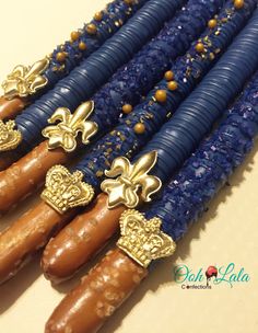 four blue beads with gold fleur de licors on them are lined up next to each other