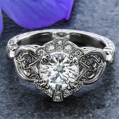 a white gold engagement ring with an old - fashioned filigreet and diamond accents