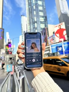 a person holding up a cell phone in the city