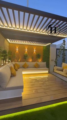 an outdoor living area with white couches and yellow pillows on the floor, under a pergolated roof