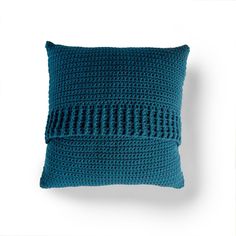 a blue crocheted pillow on a white background