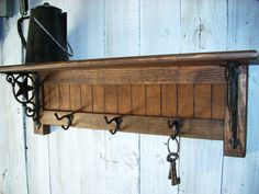 a wooden shelf with keys hanging from it's sides and hooks on the top