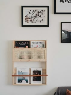 a wall with some pictures on it and two bookshelves above the bookcase