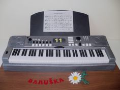 there is a cake made to look like an electronic keyboard with flowers on the side