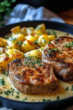 two steaks and potatoes on a black plate