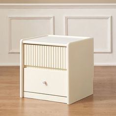 a white cabinet sitting on top of a hard wood floor