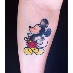 a mickey mouse tattoo on the leg