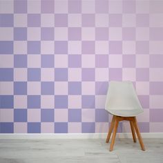 a white chair sitting in front of a wall with purple and lavender squares on it