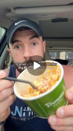 a man eating food out of a green cup in the back seat of a car