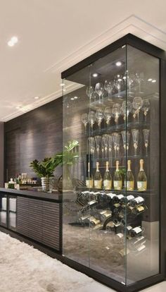 a large glass case filled with lots of bottles and glasses on top of a counter