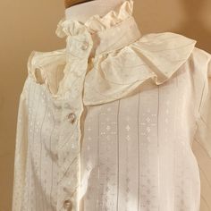 "Vintage 1980s \"Daisy Shirtworks \" Mod Fancy Party Blouse. This is a romantic lovely look in a creamy shade of ivory with gold metallic thread stripes set on a poly acetate tiny diamond Print . Blouse has a high neck ruffled Collar that has two tiers of ruffles . It's Victorian , romantic and Boho all wrapped in one . No size tags , no visible flaws . Blouse Measure shoulder to him 17 inches, chest 14 inches, sleeves shoulder to cuff 18 inches.If you need a sister said or cousin set there's a Classic Cream Top For Party, Classic Cream Party Top, Classic Cream Party Blouse, Vintage Beige Blouse For Party, Vintage Cream Blouse For Formal Occasions, Retro Cream Blouse For Formal Occasions, Cream Retro Blouse For Formal Occasions, Vintage Gold Blouse For Spring, Spring Vintage Gold Blouse