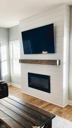 a large flat screen tv mounted on the wall above a fireplace