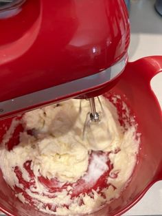 a red mixer with white batter in it