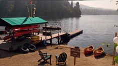 there is a boat dock on the water with two canoes parked at it's end