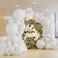 white balloons are on the floor in front of a wall with a happy birthday sign